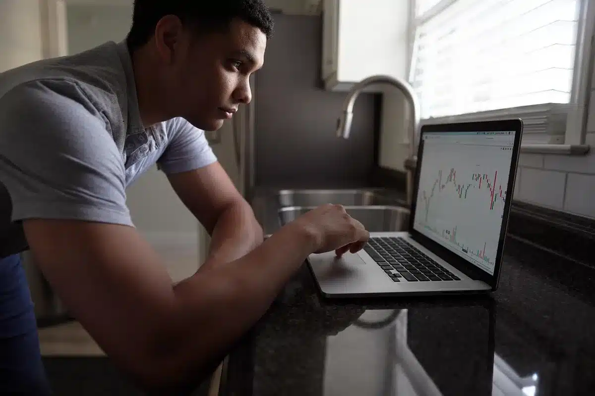 Trading floor with multiple screens showing sharp downward price movements and red market indicators during a financial