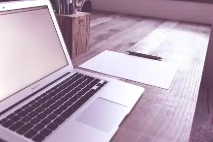 Sunlit home office desk with laptop showing an empty area in a webpage