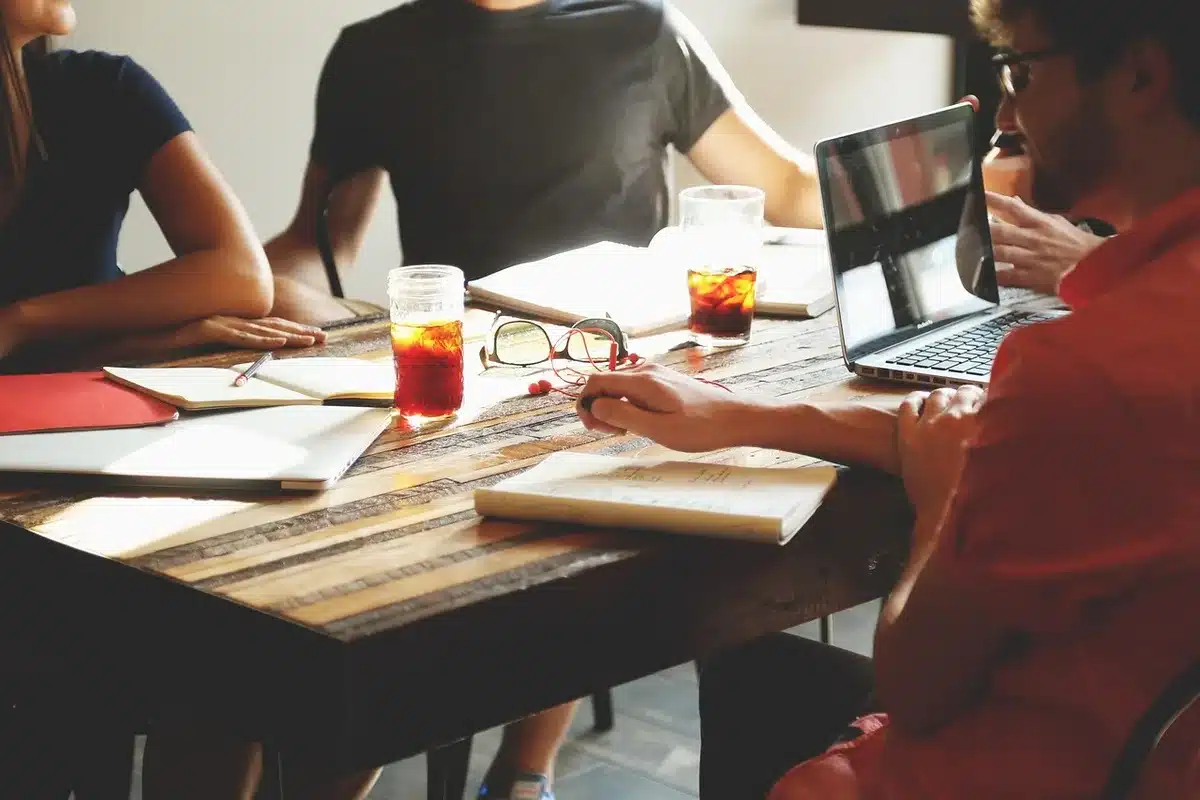 Equipo revisando una lista de verificación de cumplimiento en una mesa de reunión